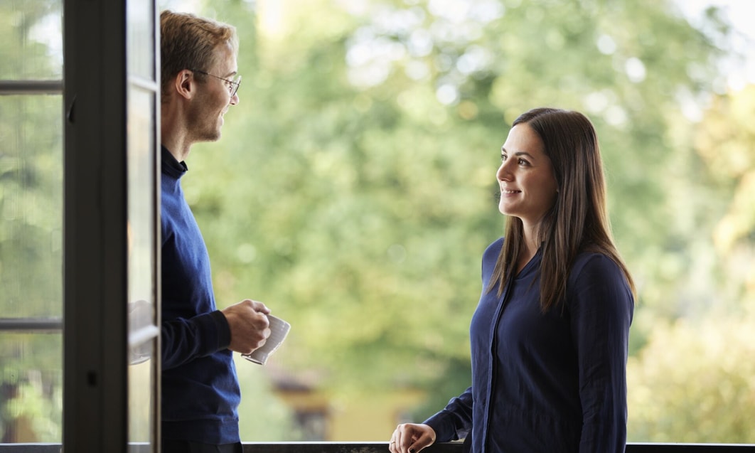a person and person standing on a balcony looking at each other