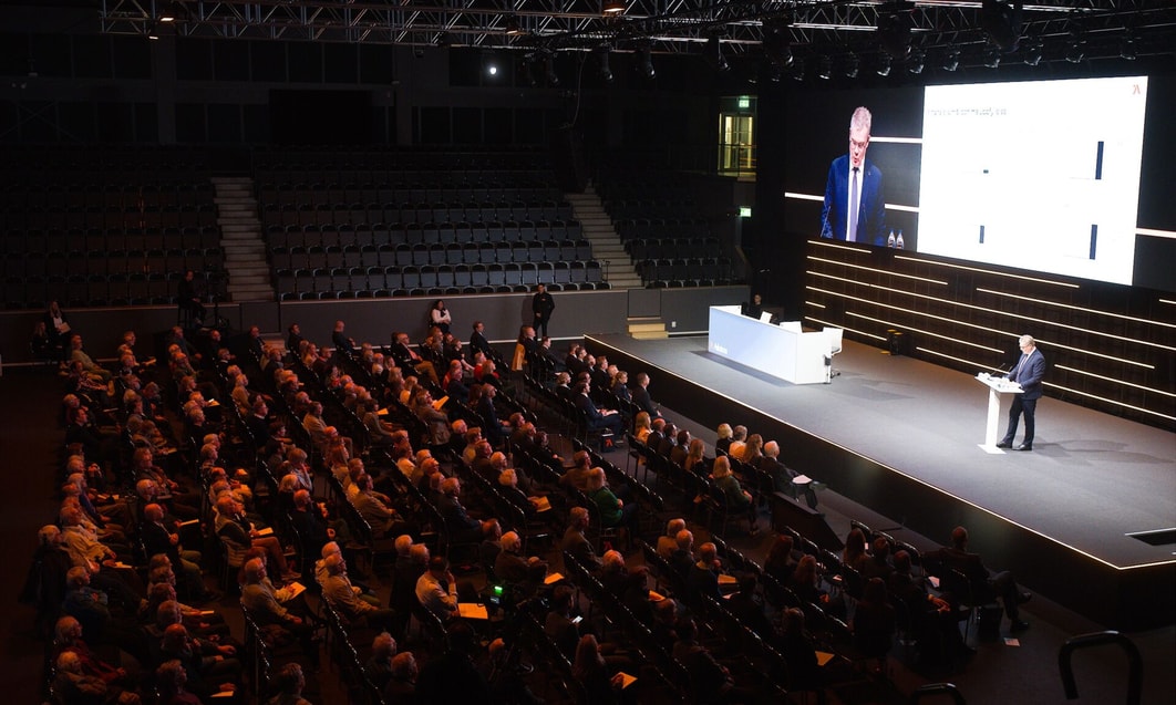 a group of people sitting in chairs in a large auditorium