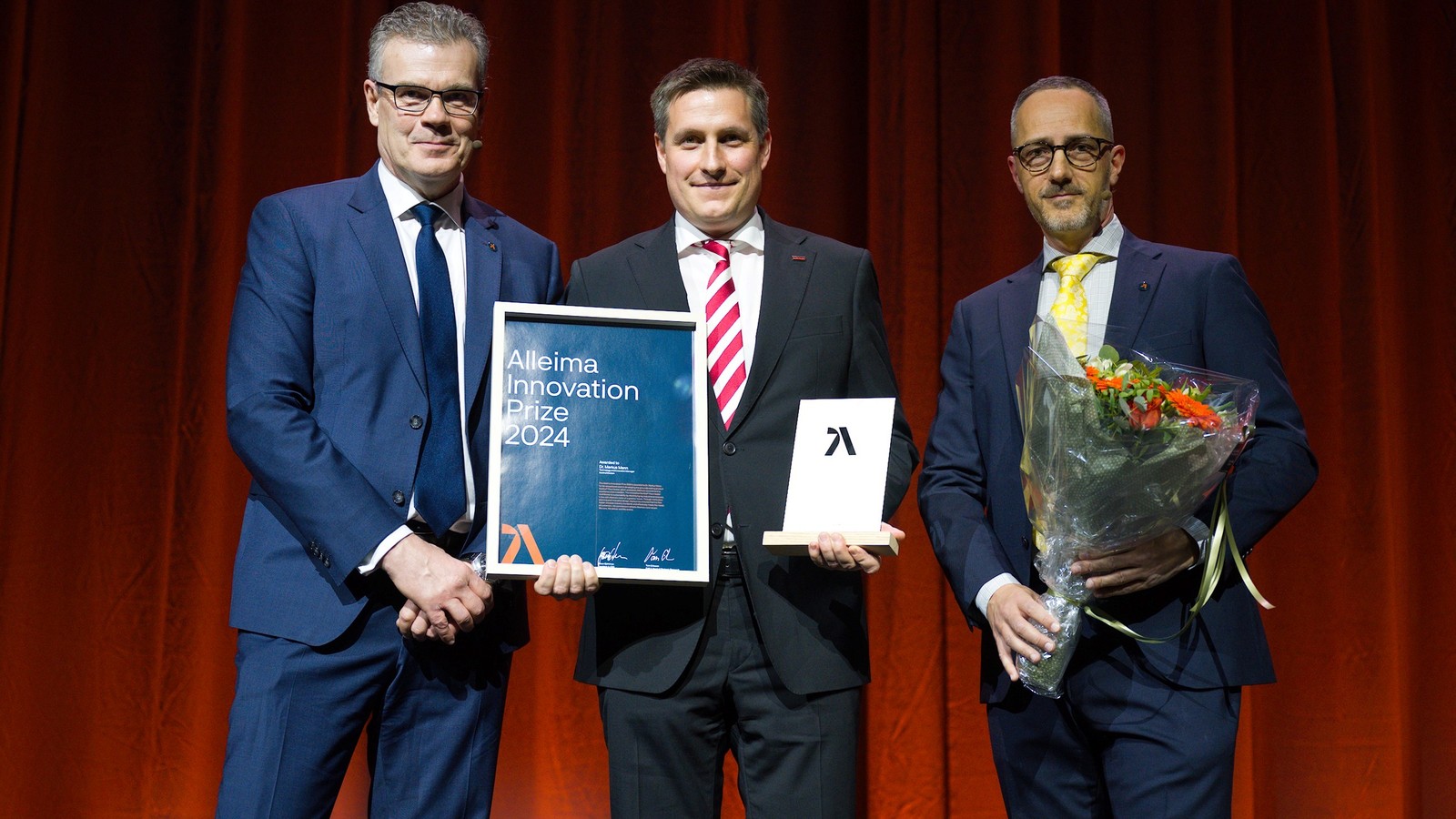 en grupp kostymklädda män med blommor och en skylt