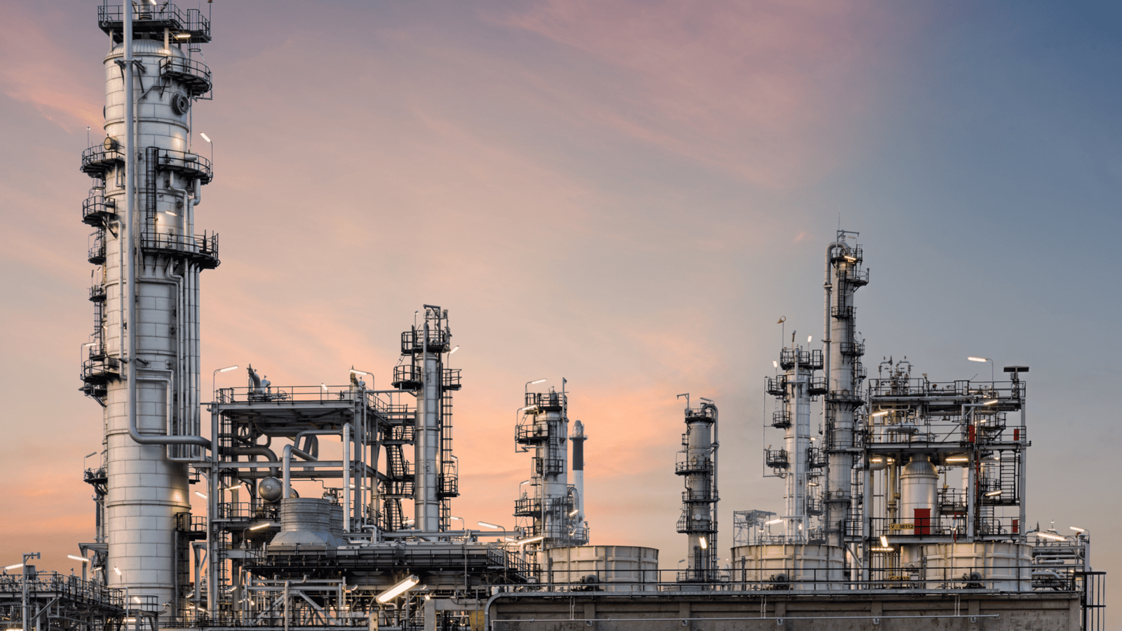a large industrial plant with towers and a wall