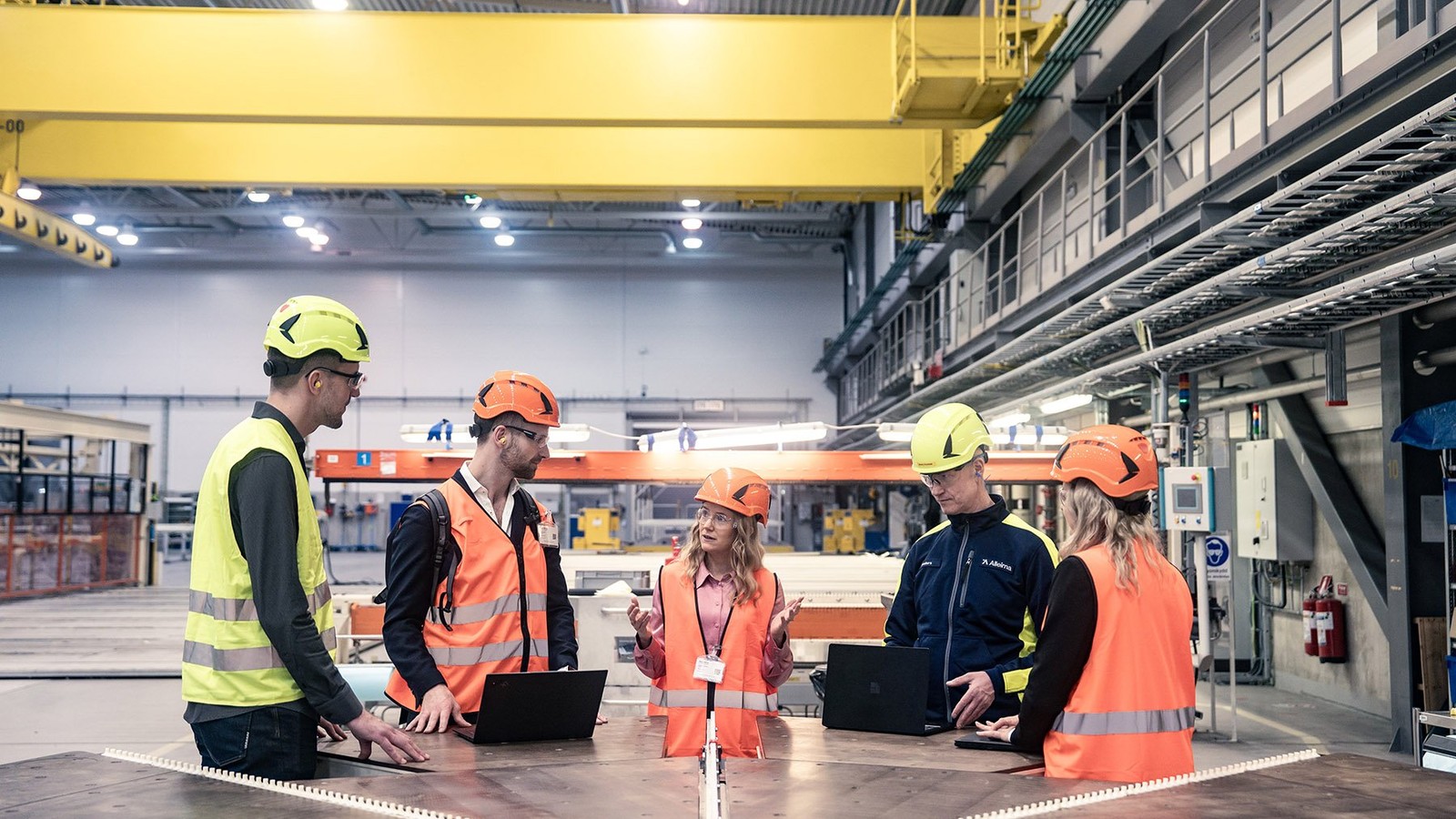 a group of people in orange vests and helmets