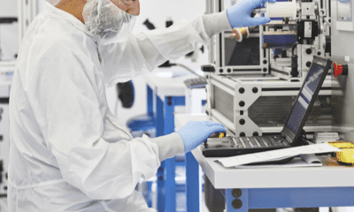 a person in a white suit and gloves working on a laptop