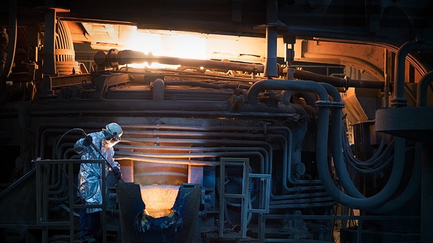 a person in a white suit and mask working in a factory